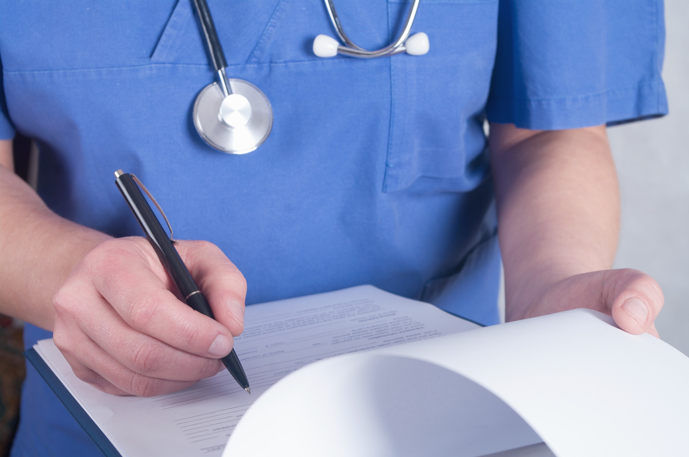 doctor writing with stethoscope